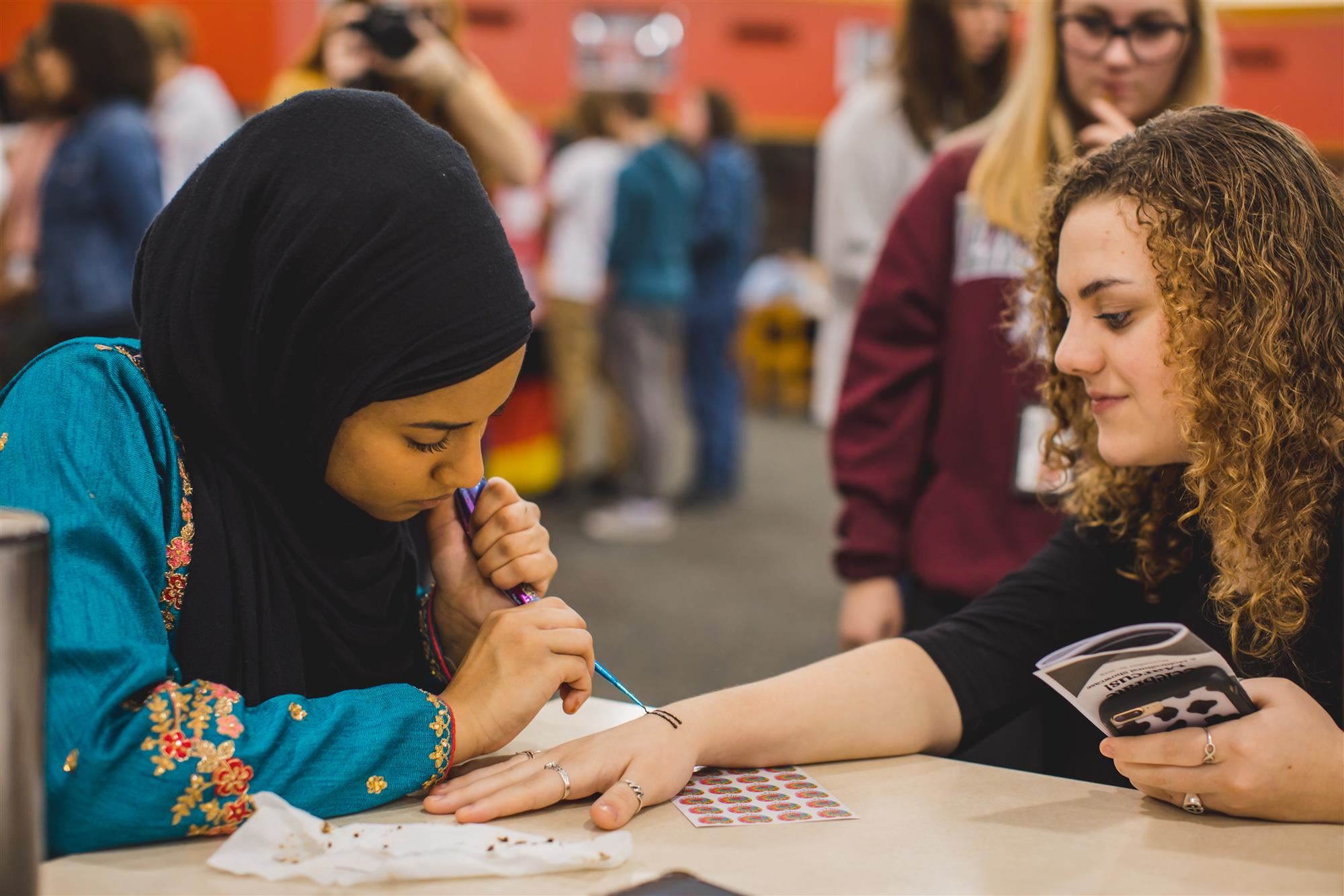 MHS student gives fellow student a henna tattoo at Celebrate Marcus! 20  