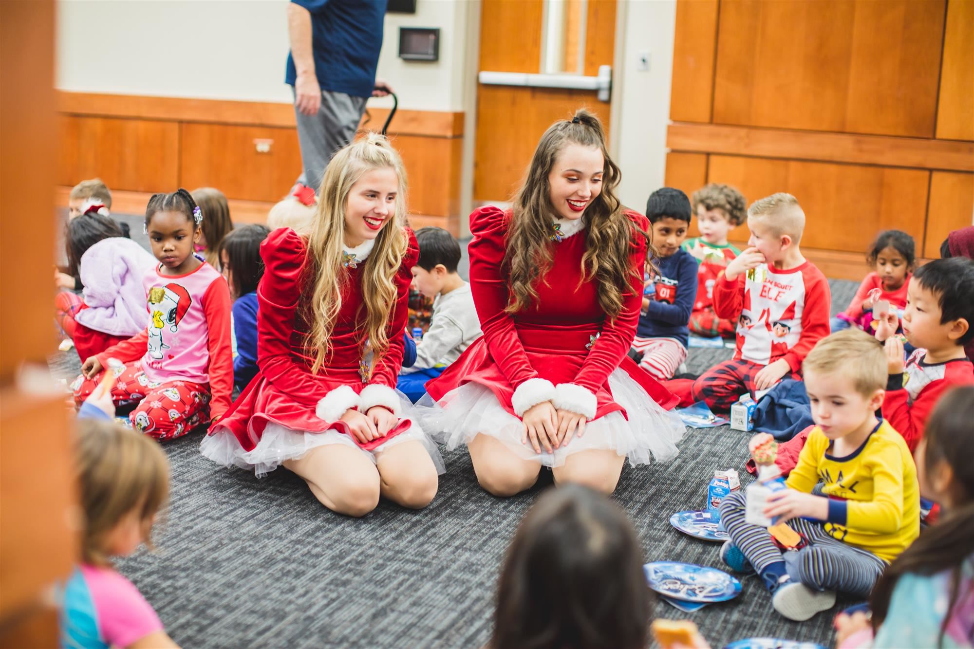 Flower Mound High School Drill Team members talk with Forest Vista Elementary Kindergartners while they eat their cookies. 