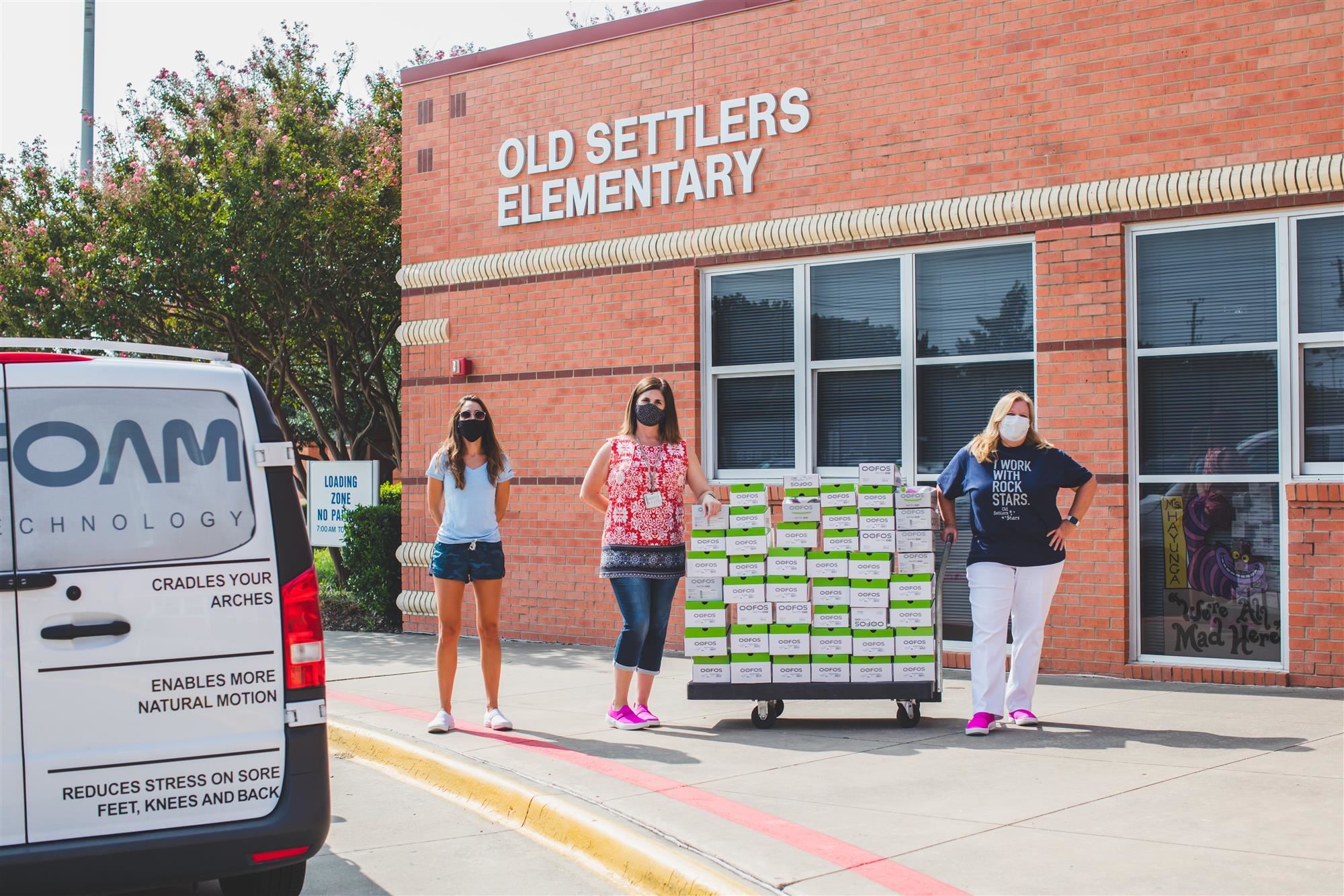 Old Settlers staff pose with their new OOFOS outside school. 2020 