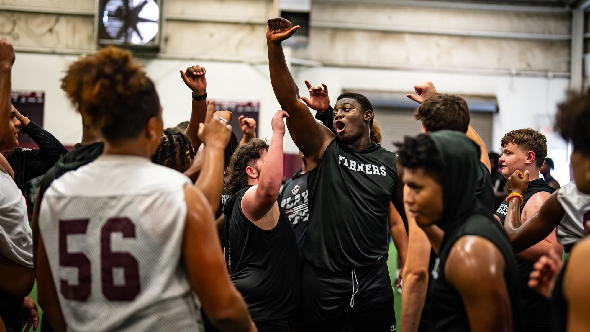 Michael Fasusi leads his teammates in a cheer following the end of football practice.