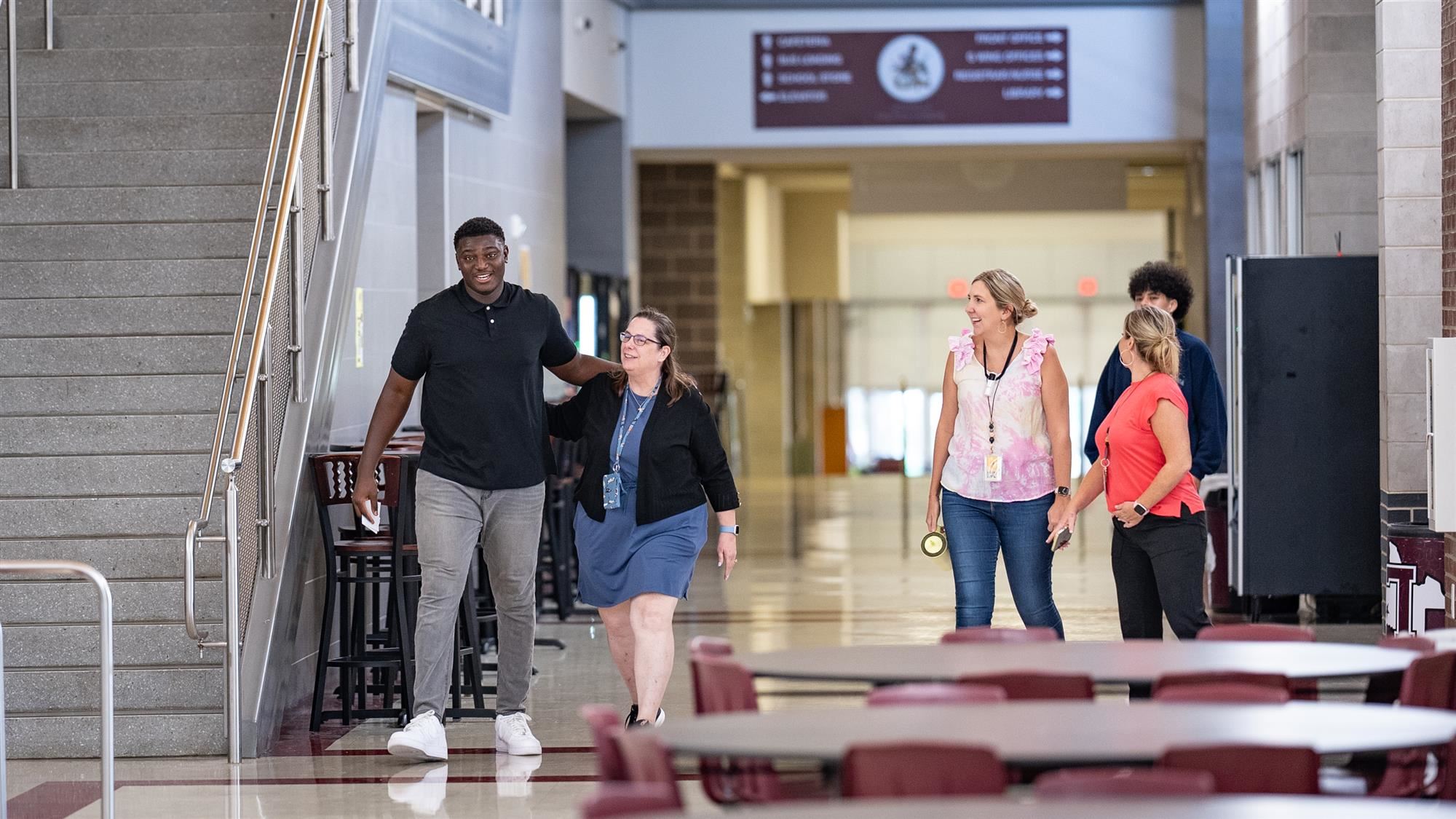 Michael Fasusi walks to the LHS auditorium with his former teachers at Lewisville High School