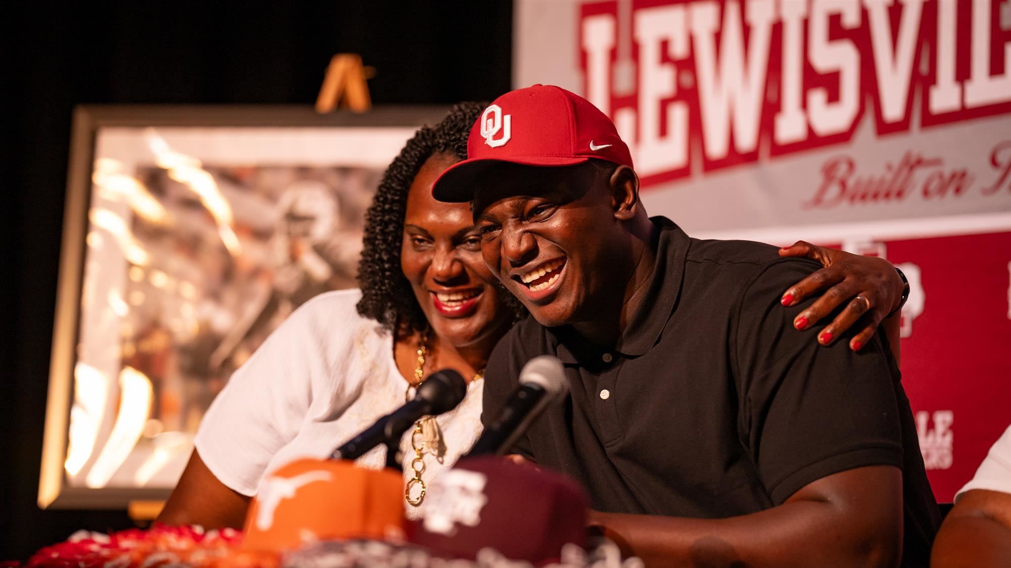 Michael Fasusi and his mother embrace after he announces his commitment to Oklahoma University.