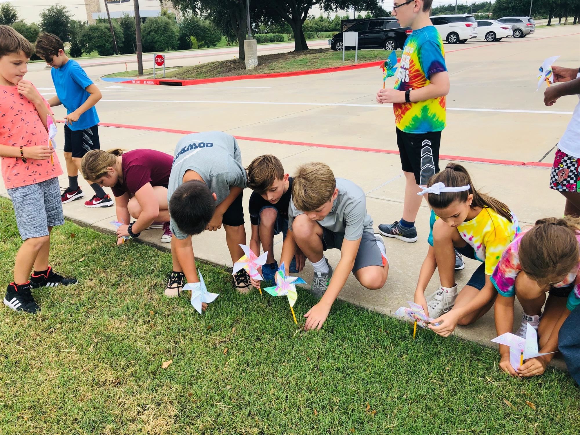 Bluebonnet students place their pinwheels in the grass outside school for world peace. 2019 