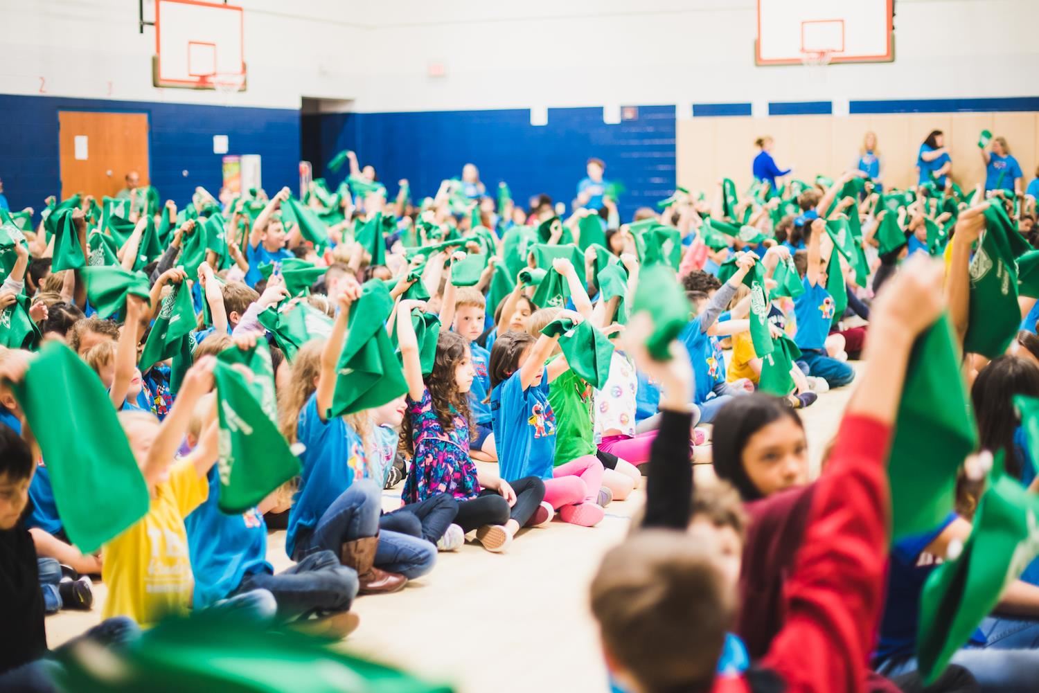 Students waving green rally towels 