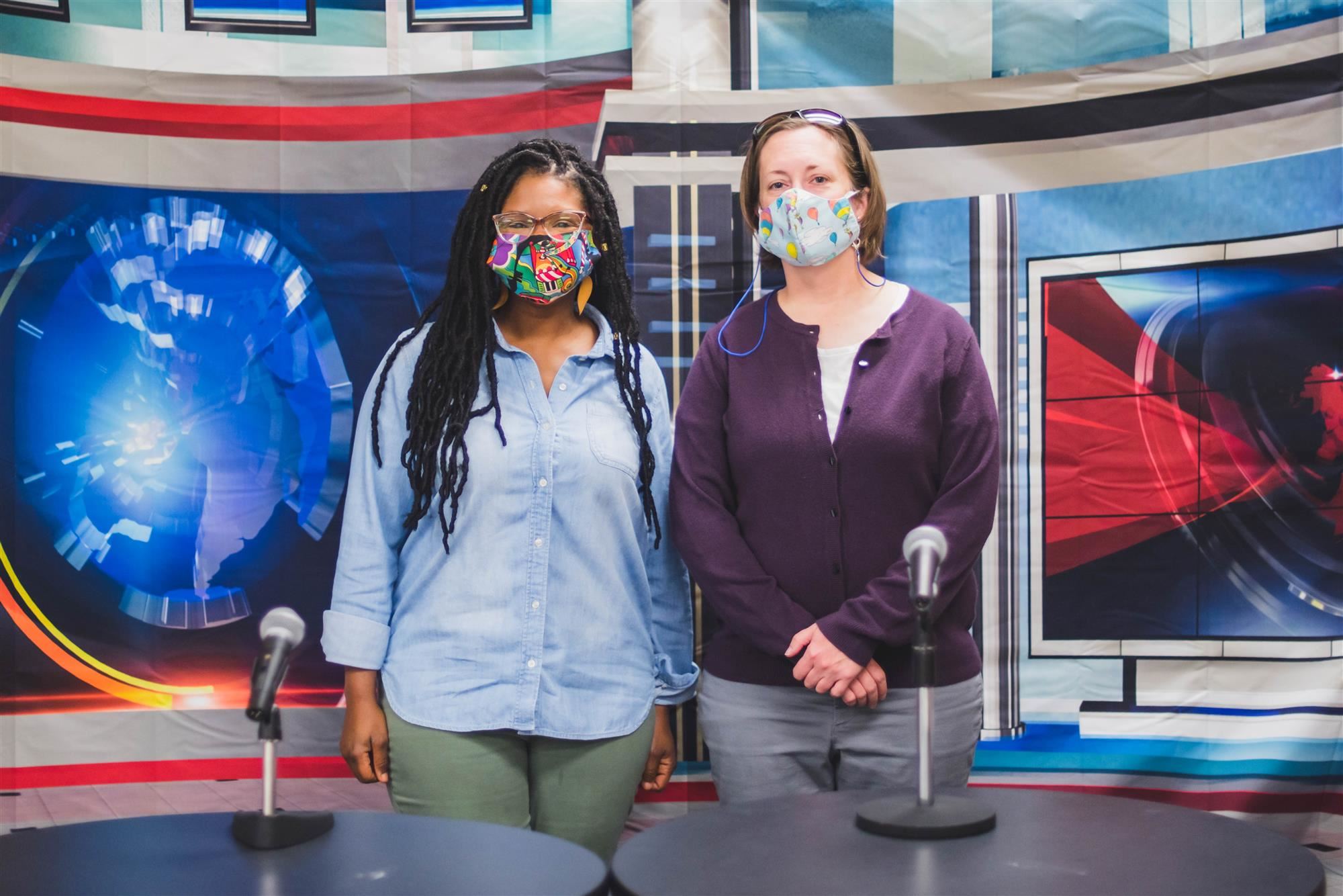 Two teachers smiling by morning show mics 