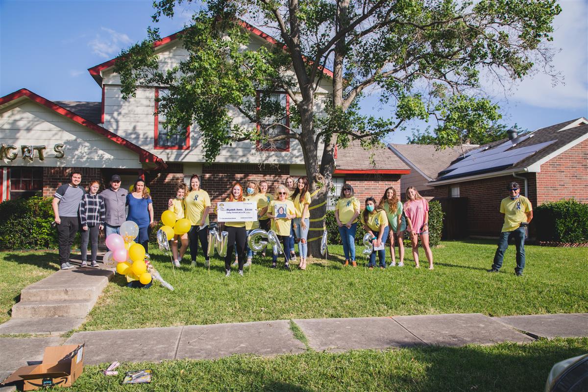 Group gathers for a photo, social distancing as much as possible. 