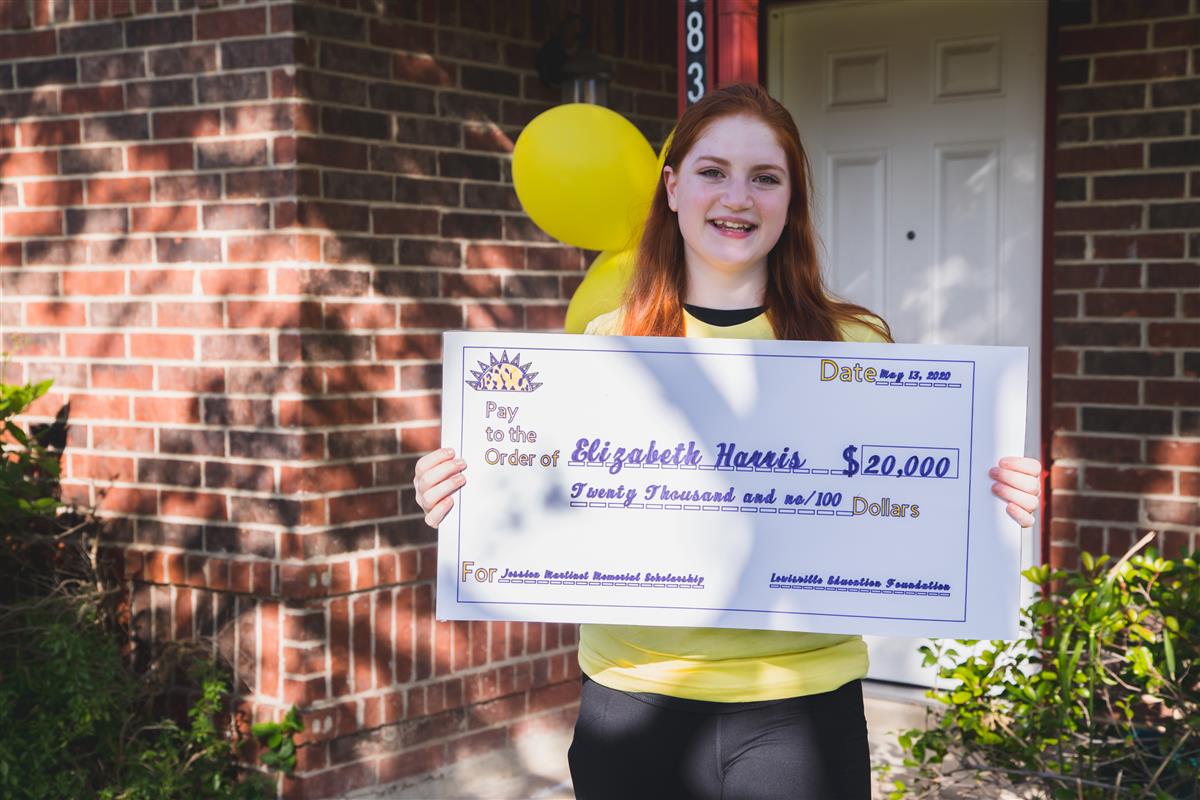 Elizabeth holding her $20,000 check. 