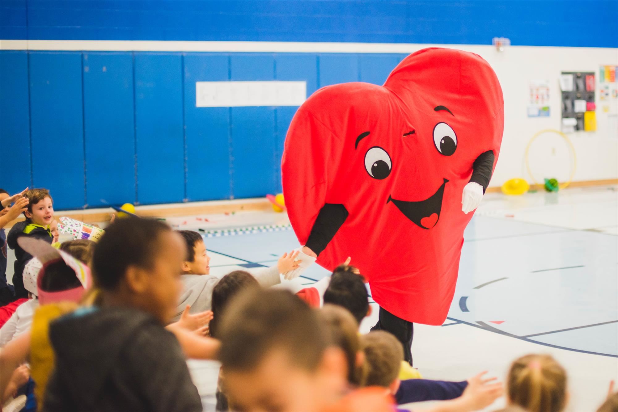 heart mascot greets students with high fives 