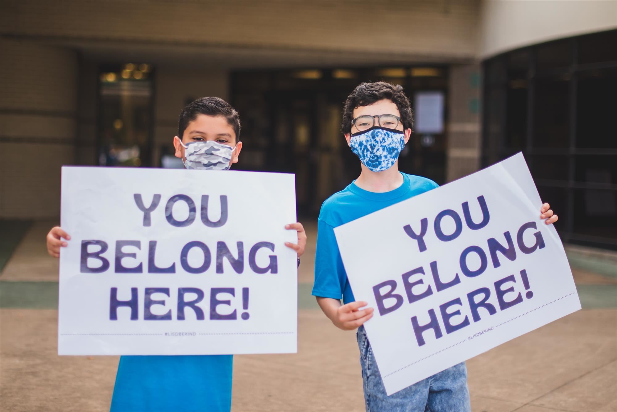 Students hold "You belong here" signs