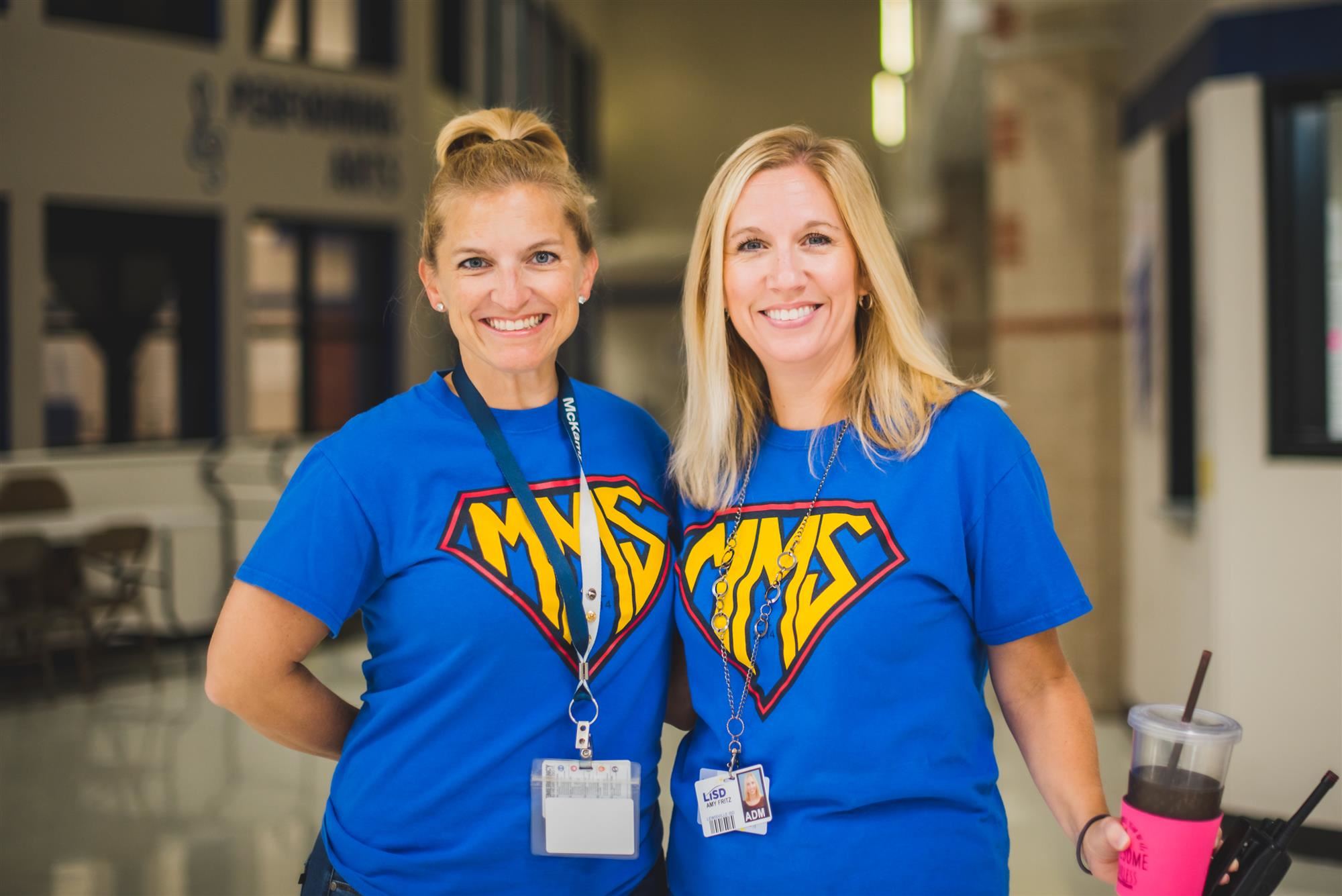 Teachers smile in superhero shirts