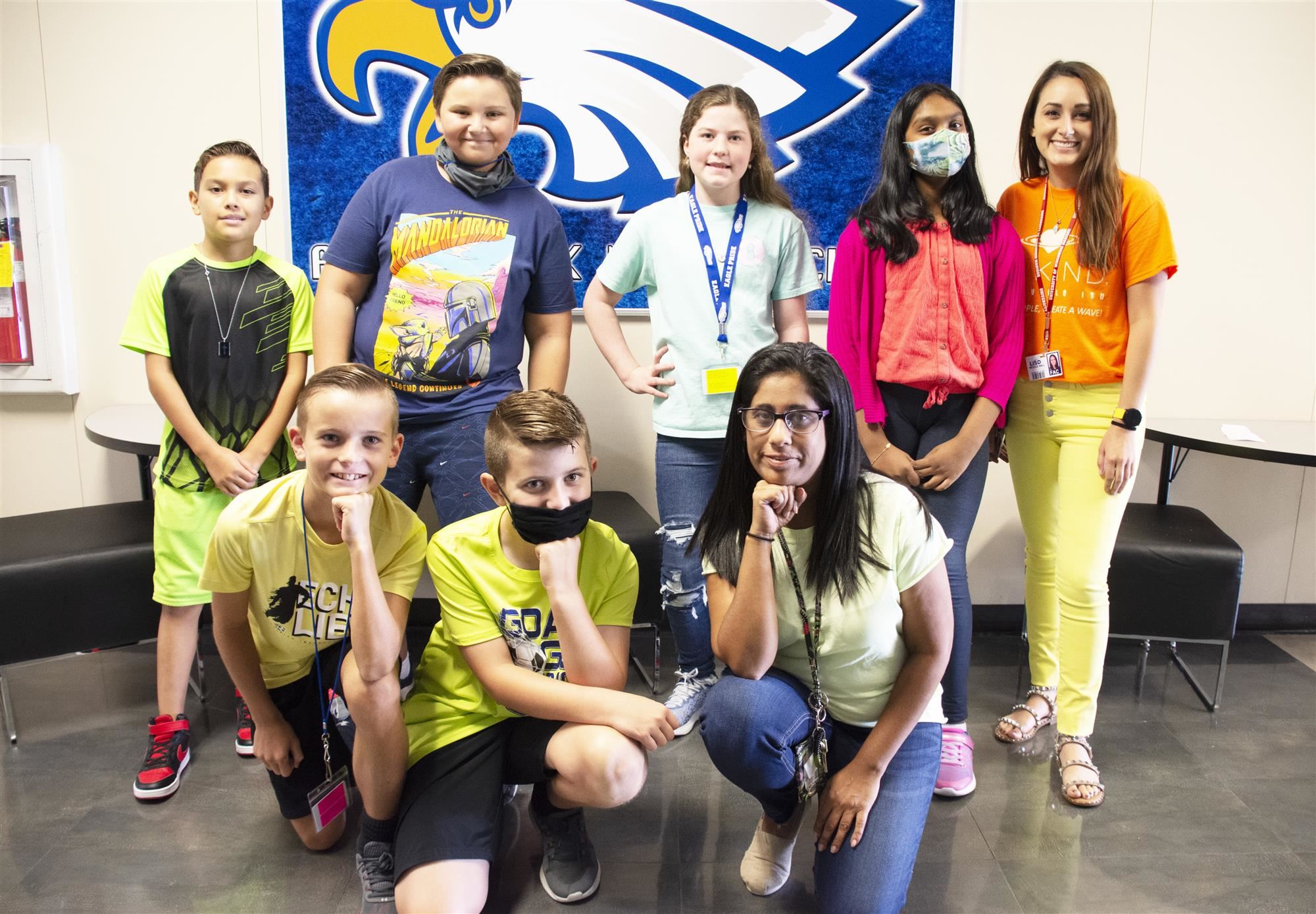 Students in neon smile for group photo