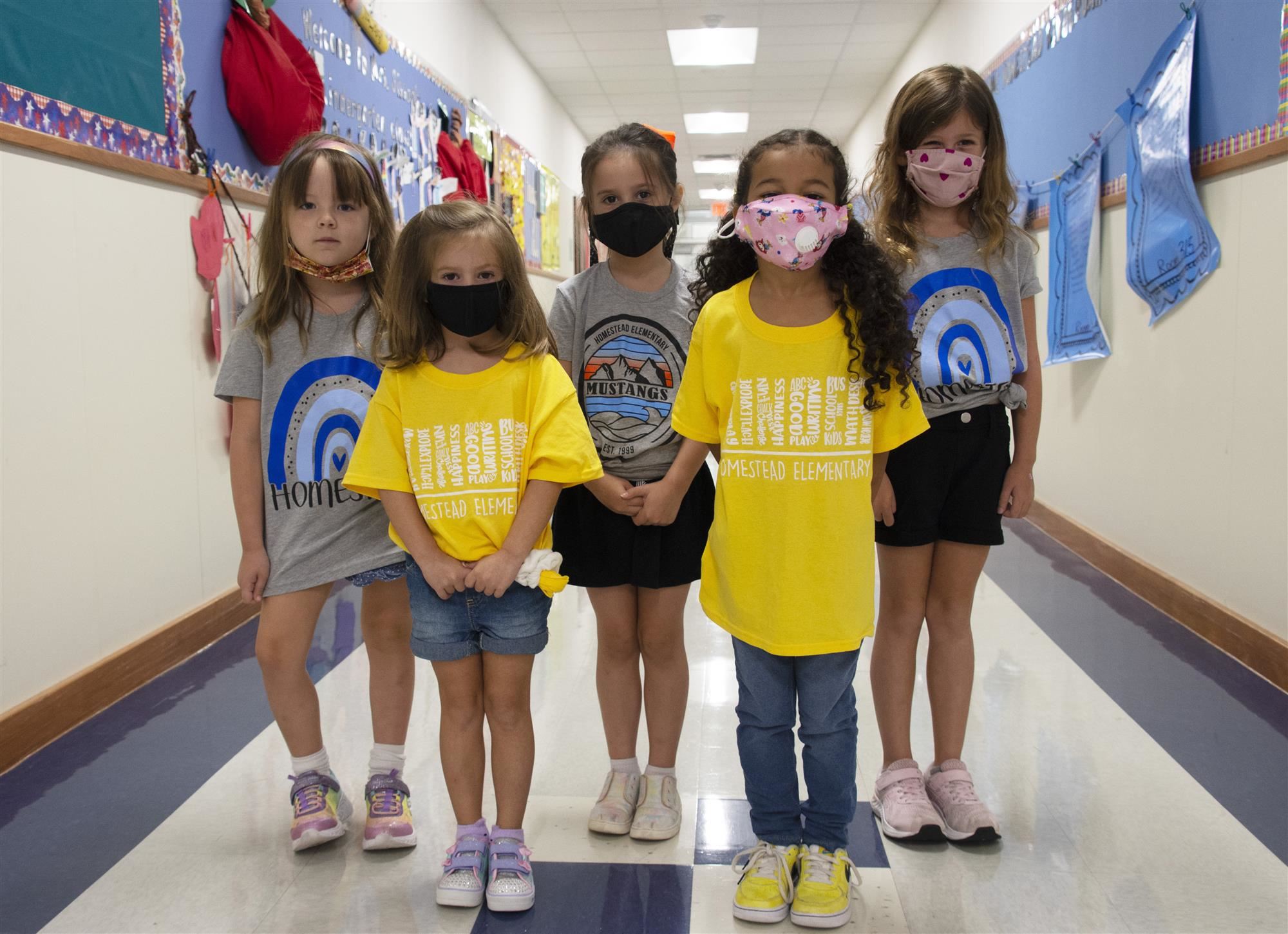 Students in team shirts stand in hallway