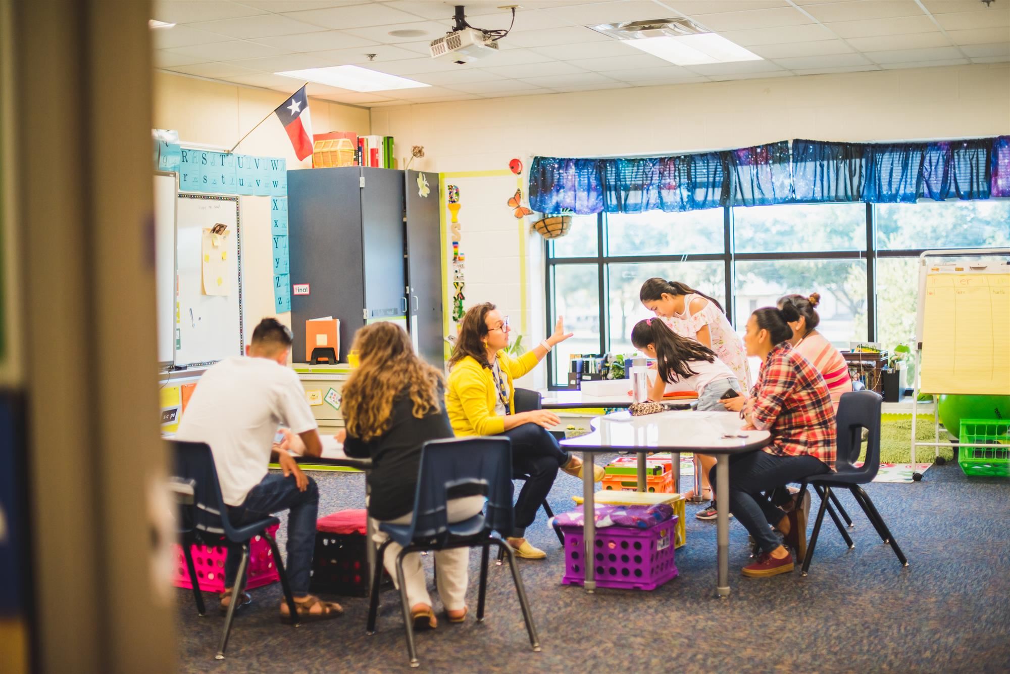 Teachers speak to parents and students in classroom. 