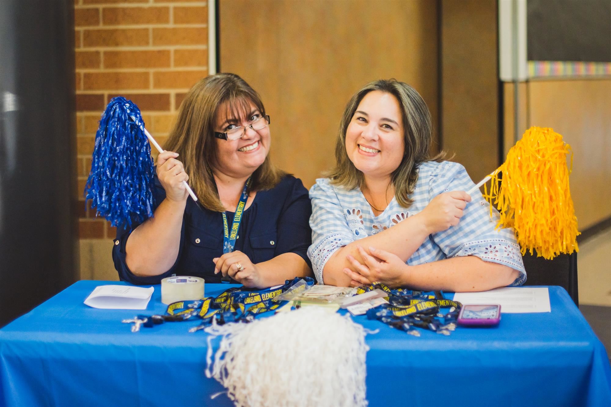 Lakeland staff smile and pose with pom poms. 