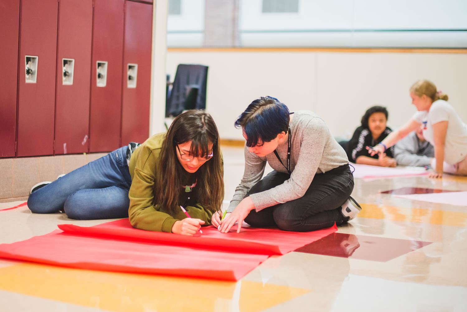 Students work on spirit signs in the hallway 