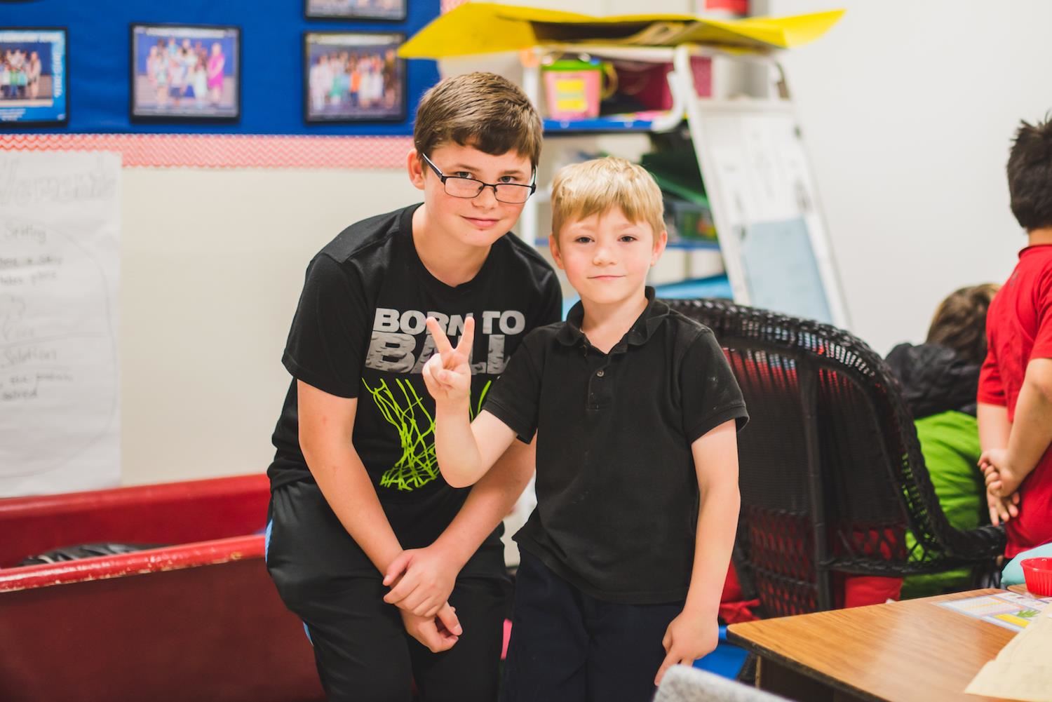 Middle school and elementary school students smile for photo 