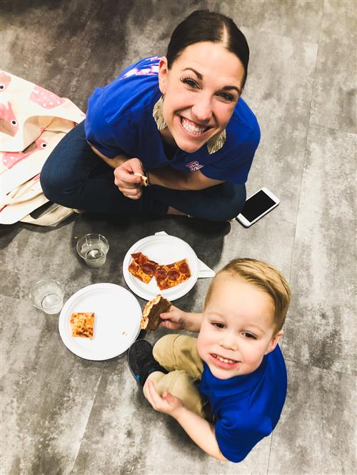 Student and teacher eating pizza and smiling 