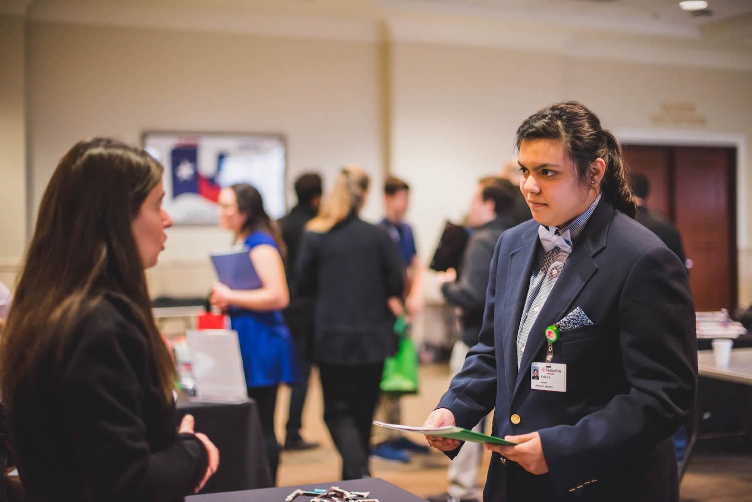 student talks with potential employee at job fair 