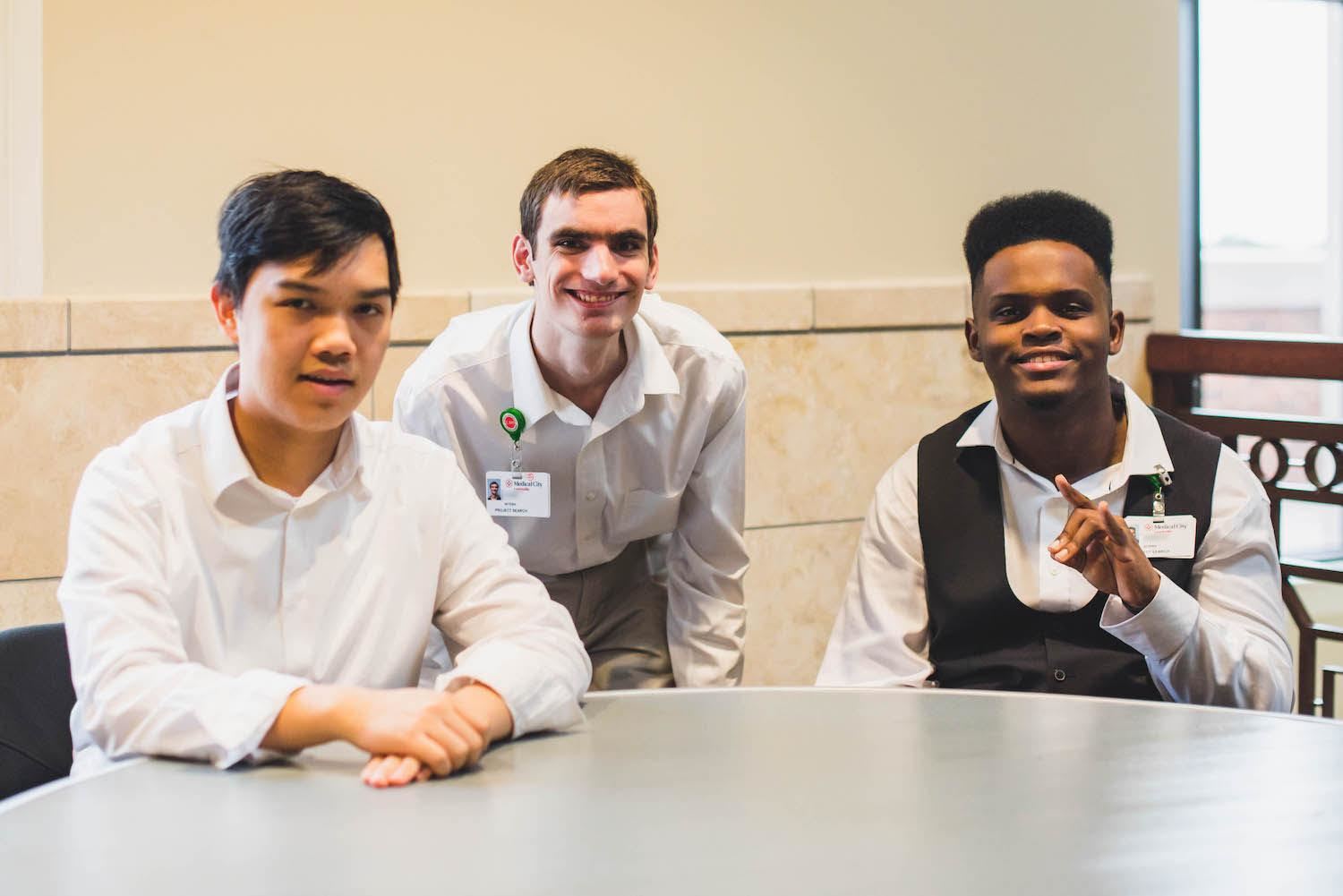 Three students smile for the camera 