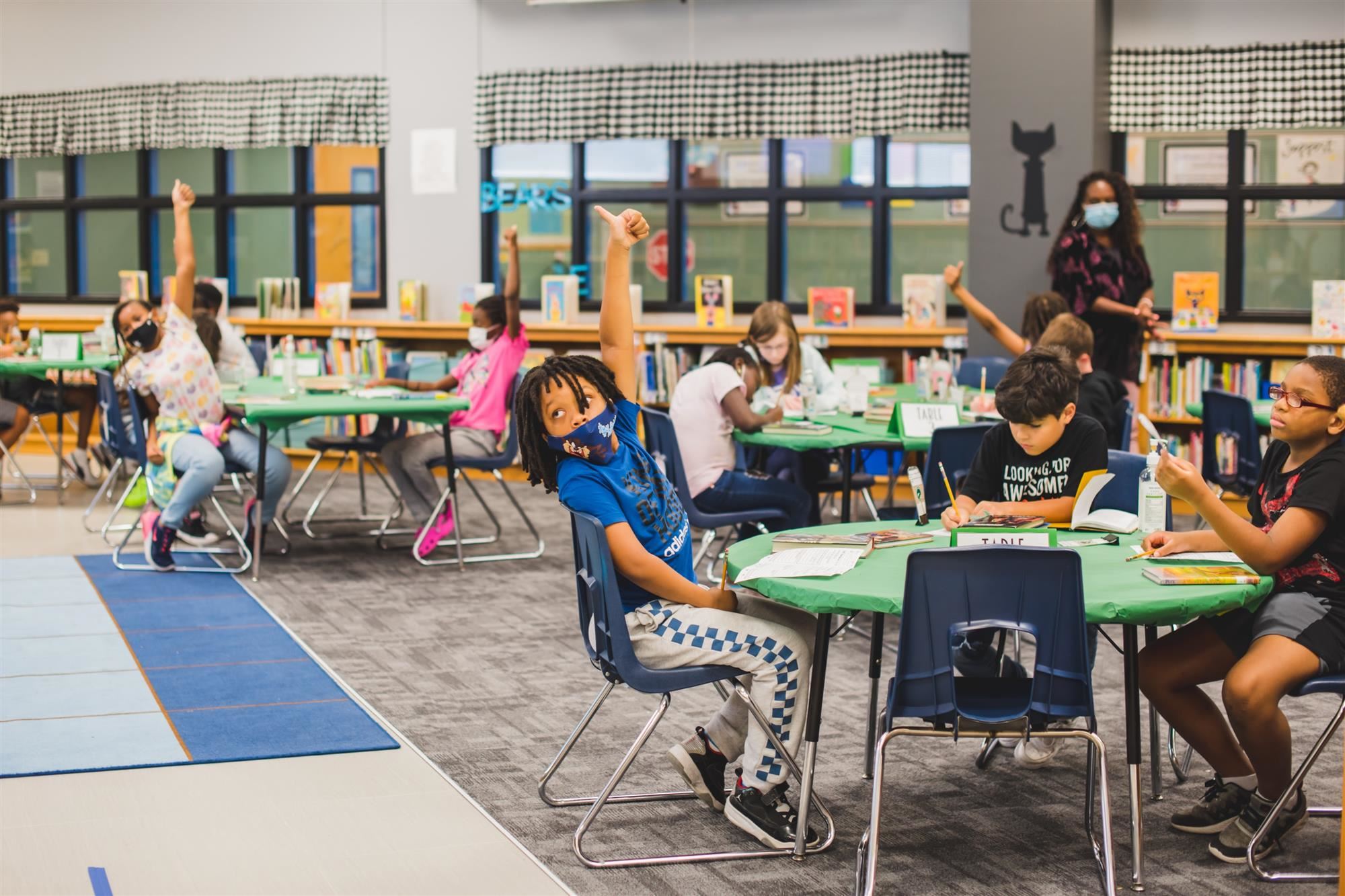 Students in library give a thumbs up