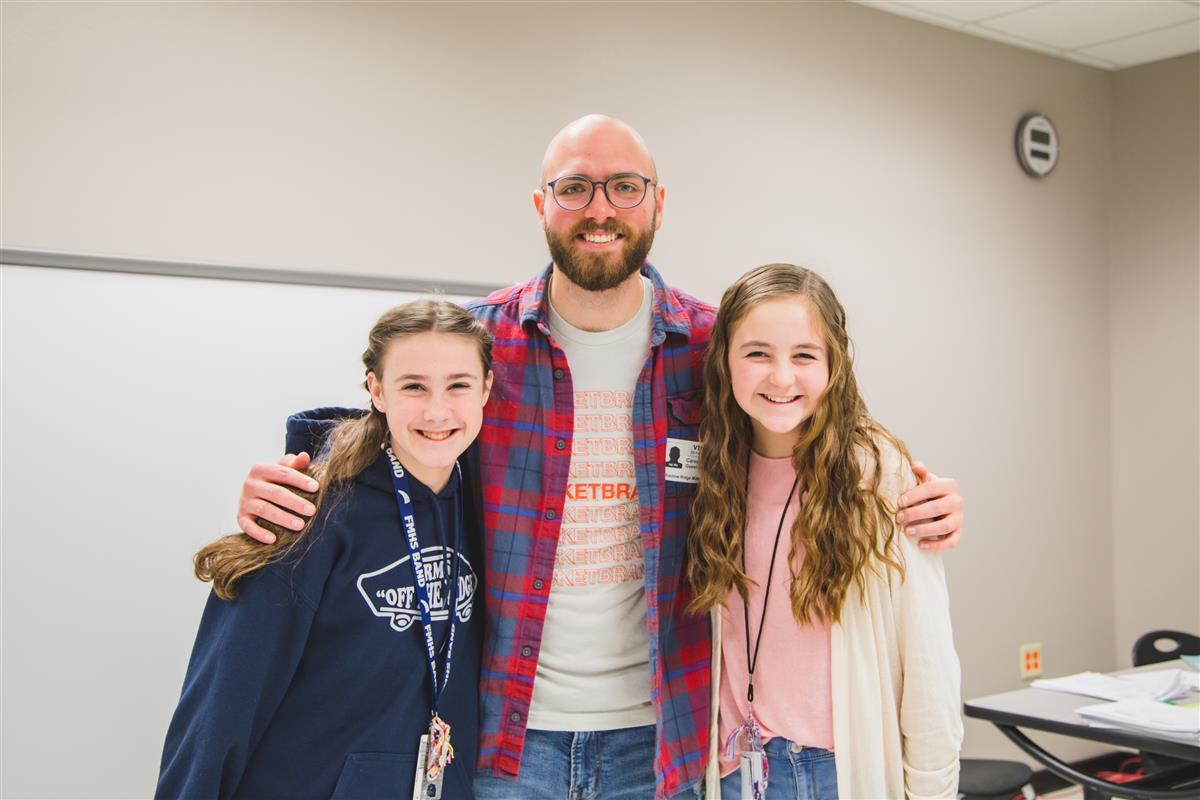 Students take a photo with a career day presenter. 