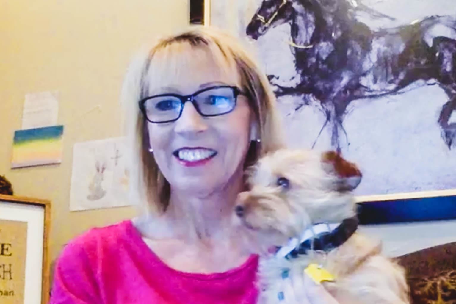 teacher and dog smile at webcam 