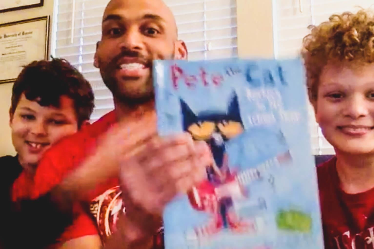 assistant principal and kids read a book called Pete the Cat 